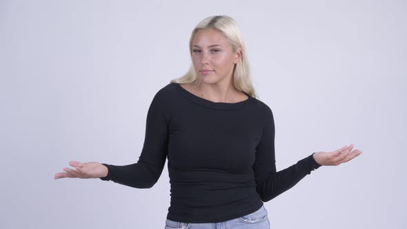 Young Confused Blonde Woman Shrugging Shoulders