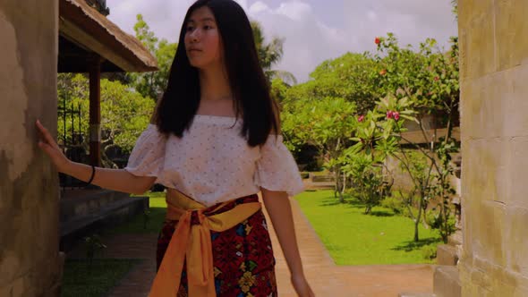 Teenage Chinese tourist explores a temple in Bali.