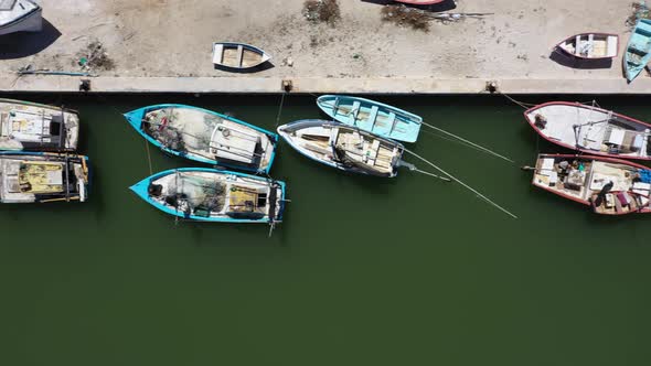 Aerial view looking straight down and camera sliding to the right showing small wooden fishing boats