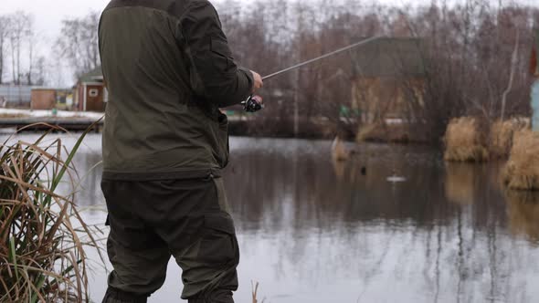 Unrecognizable Man Fishing in Lake at Dawn