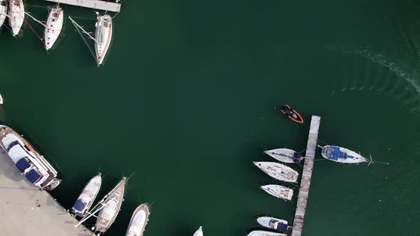 Aerial top drone view of a lot of white yachts and sailboats moored in marina on a turquoise water
