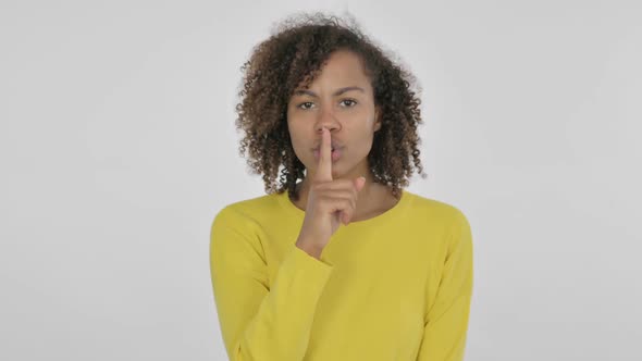 Young African Woman with Finger on Lips Silence White Screen