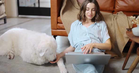 Woman with a Dog and Laptop at Home