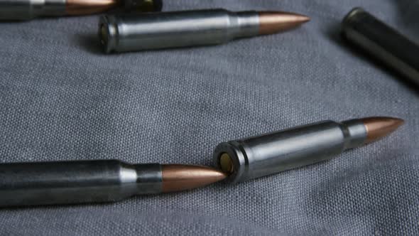 Cinematic rotating shot of bullets on a fabric surface 