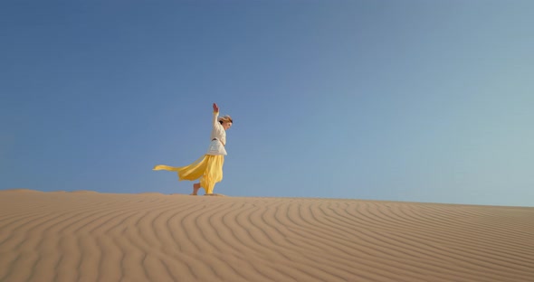  Slow Motion Fashion Background. Woman in Desert with Blue Space for Copy