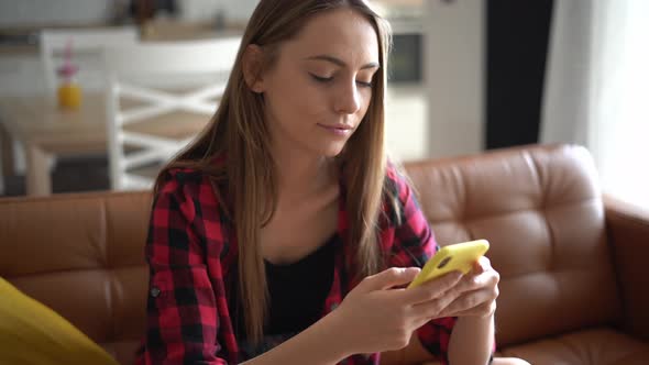 Beautiful young woman writing text message on her smartphone