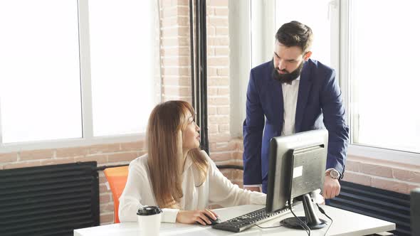 Young Businesss Ladies Sitting in Modern Office and Using Computer Discussing