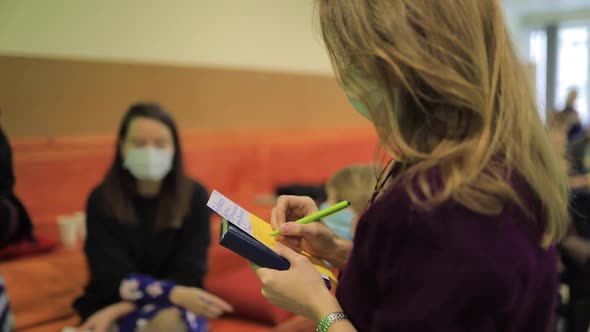 Girl Writes at the Event with a Pencil Marker on a Sheet