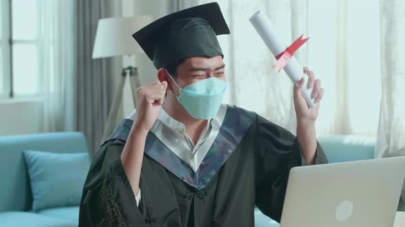 Asian Man Wearing Protection Face Mask And Celebrating With University Certificate During Video Call