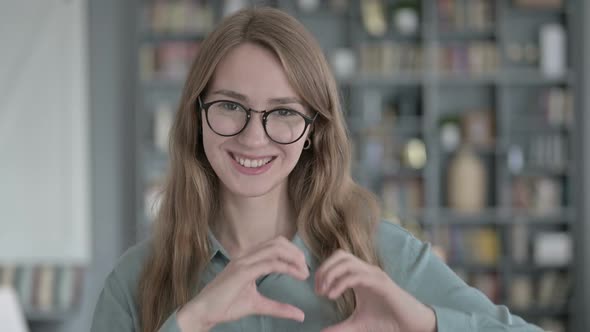 Portrait of Cheerful Young Woman Making Heart Shape with Hands
