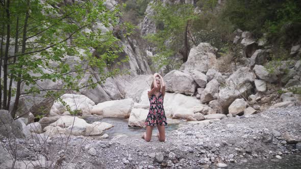 Yoga in the Forest Spiritful Woman in Light Dress Standing with Her Knees on the Pebbles and Doing