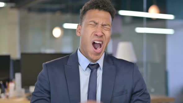 Portrait of Sleepy Young Businessman Yawning in Office 