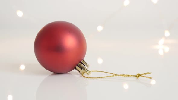 Golden string on red color bauble slow tilt 4K 2160p 30fps UltraHD  footage - Round Christmas orname