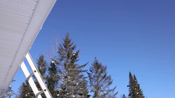 Removing Fresh Snow From a Roof in a Sunny Winter Day
