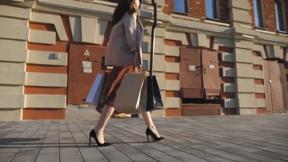 Fashionable Woman Carries Paper Packages Going Along Urban Street