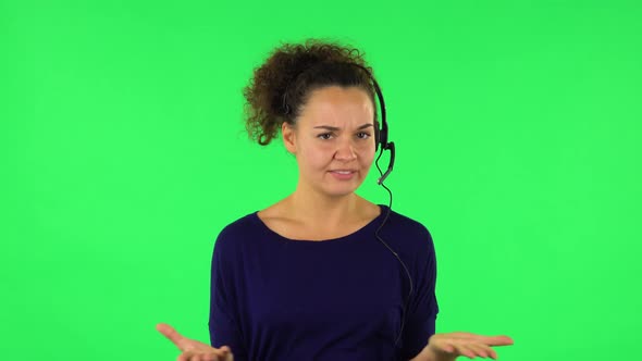 Portrait of Curly Woman Talking on Headphones, Call Center. Green Screen