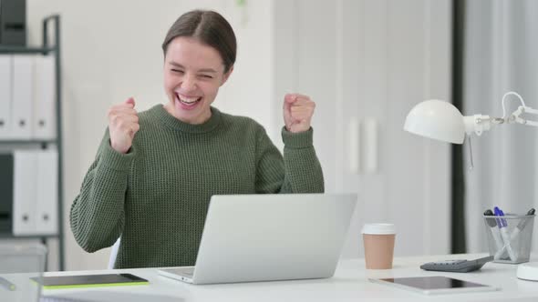 Young Woman with Laptop Celebrating Success 