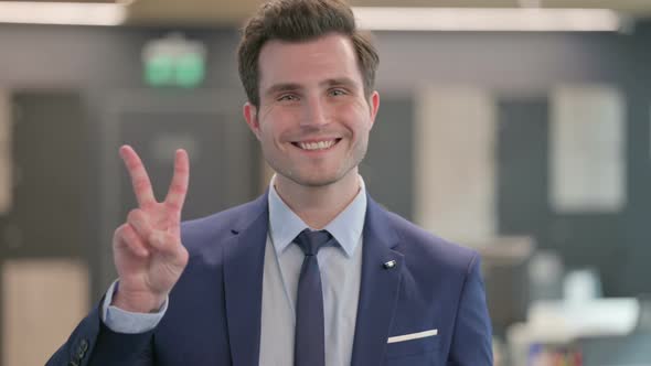 Portrait of Businessman Showing Victory Sign with Finger