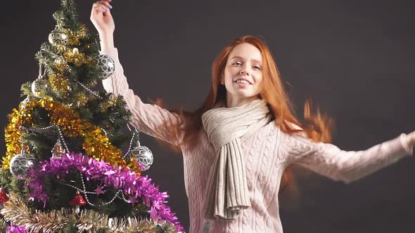 Beautiful Smiling Girl Smoothly Dancing Near Christmas Tree in Studio