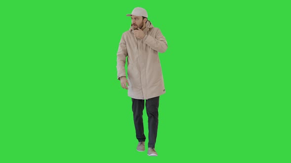 Man in Winter Outfit Walking and Coughing on a Green Screen, Chroma Key.