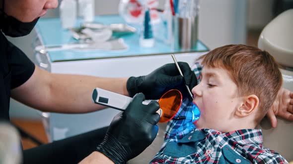A Little Boy Having His Teeth Done - Putting the Photopolymer Lamp in the Mouth and Turning It on