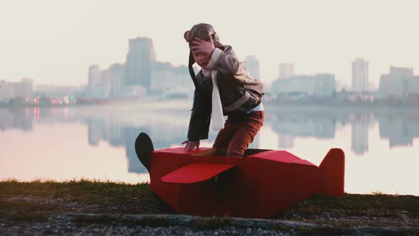 Little Happy Pilot Boy Getting Into Fun Red Cardboard Plane Costume at Amazing Peaceful City Lake