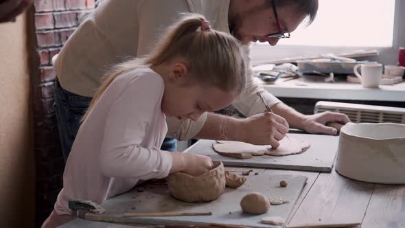 Ceramist Person Man and Little Girl Making Earthenware in Studio