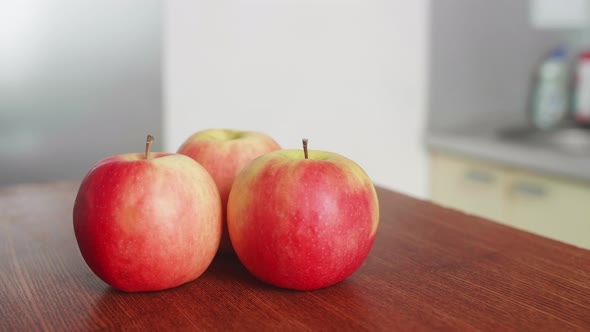 Red Apples on the Kitchen Wooden Table The camera Moves Around in the kitchen