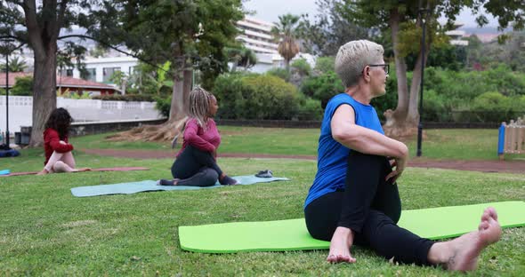 Multiracial people doing yoga class at city park - Healthy lifestyle and sport concept