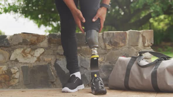 Front view man readjusting his prosthetic leg