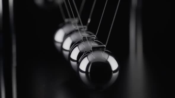 The balls of a Newtons Cradle colliding in slow motion alt