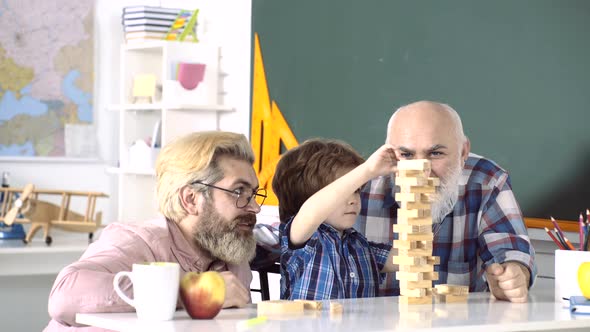 Grangfather, Father and Son Playing Game at Home. Men Family. Pupil with Dad and Granddad Enjoying