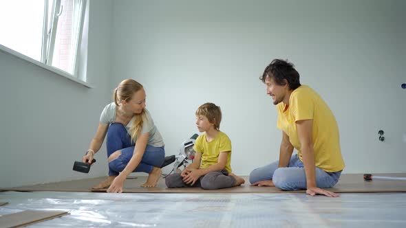 A Family of Mother Father and Son Install Laminate on the Floor in Their Apartment