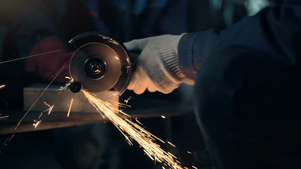 Worker Cuts Metal with Hand Disc Grinder Abrasive Saw