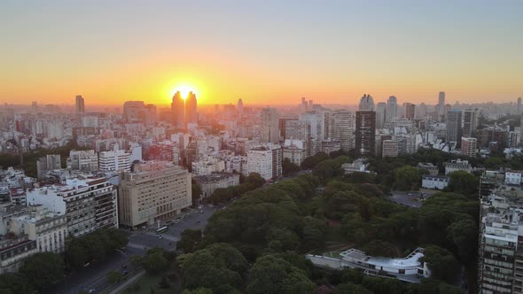 Dolly out flying over Recoleta neighborhood squares and buildings at golden hour, Buenos Aires