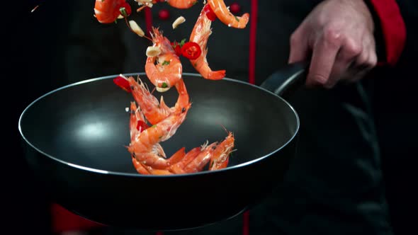 Super Slow Motion Shot of Chef Holding Frying Pan and Falling Shrimps at 1000Fps.