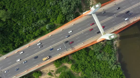 City caring at highway bridge on background smooth river surface drone view