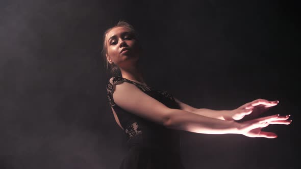 Young Woman Ballerina in Black Dress Slowly Moving Her Hands