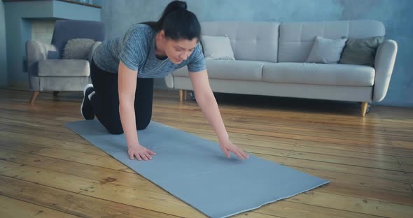 Sportive Woman Does Plank Exercise in Room