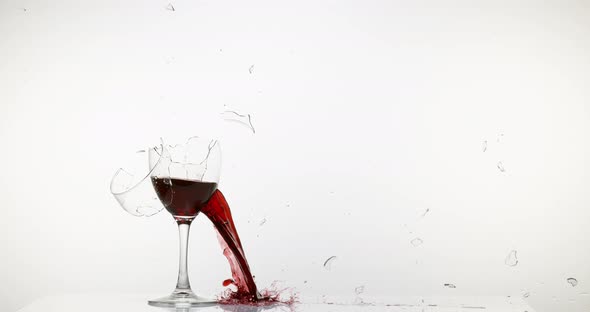 900130 Glass of Red Wine Breaking and Splashing against White Background, Slow motion 4K
