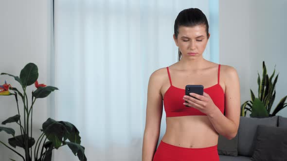 Portrait Serious Athletic Fitness Woman Uses Smartphone Raises Head Looks Camera