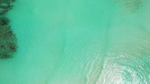 Natural fly over copy space shot of a sandy white paradise beach and turquoise sea background