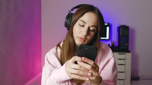 Worried Young Woman Holding Phone Feeling Jealousy Anxiety Waiting for Mobile Call Sit Alone at Home