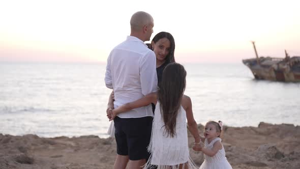 Loving Carefree Man and Woman Dancing with Daughters Holding Hands Walking Around Happy Couple of