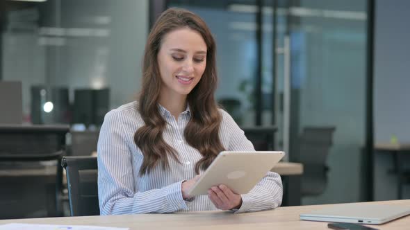 Attractive Young Businesswoman using Tablet at Work