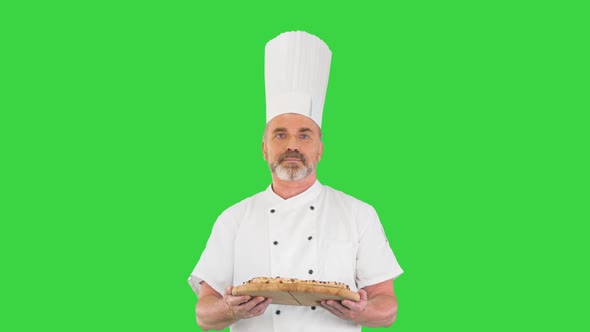 Senior Cook with a Pizza in Hands Walking on a Green Screen Chroma Key