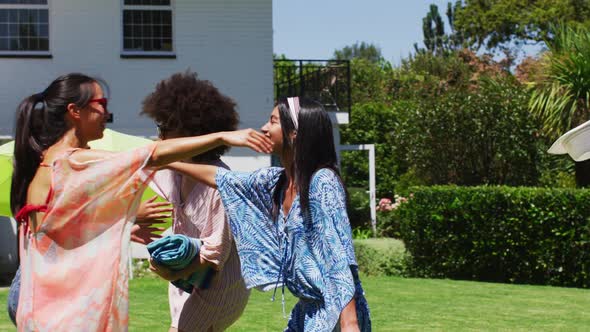 Diverse group of friends greeting and embracing at a pool party