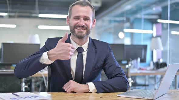 Cheerful Young Businessman Showing Thumbs Up