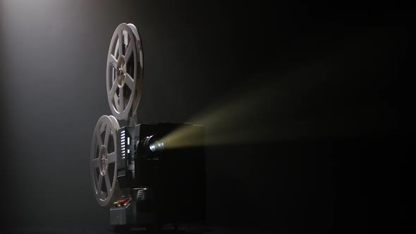 Projector Illuminated By Lights Broadcasts a Movies. Dark Studio