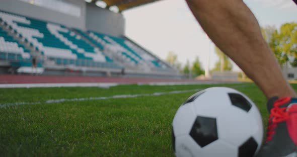 Close Up of a Male Soccer Player Running with a Soccer Ball on the Football Field in the Stadium